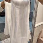Plain white chiffon hijab hanging on a hanger in fitting room